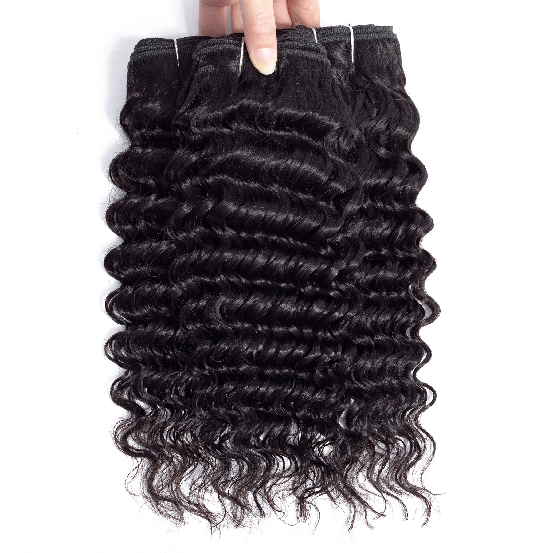 Real Sahar hair wefts held by hand, showing visible curled texture